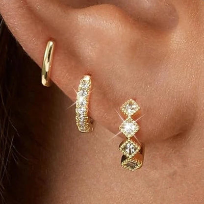 Set of 3 gold stainless steel hoop earrings and zircon flower studs by DoubleMfashion, displayed on a white background.