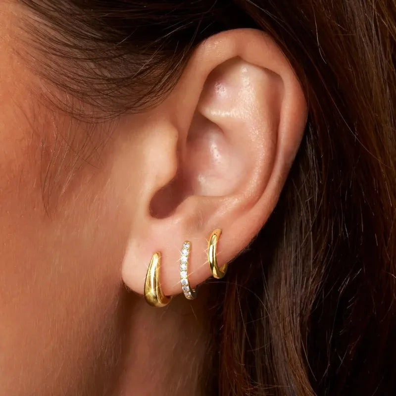Three pairs of gold-plated hoop earrings with crystal zirconia for women by DoubleMfashion, displayed on a neutral background.