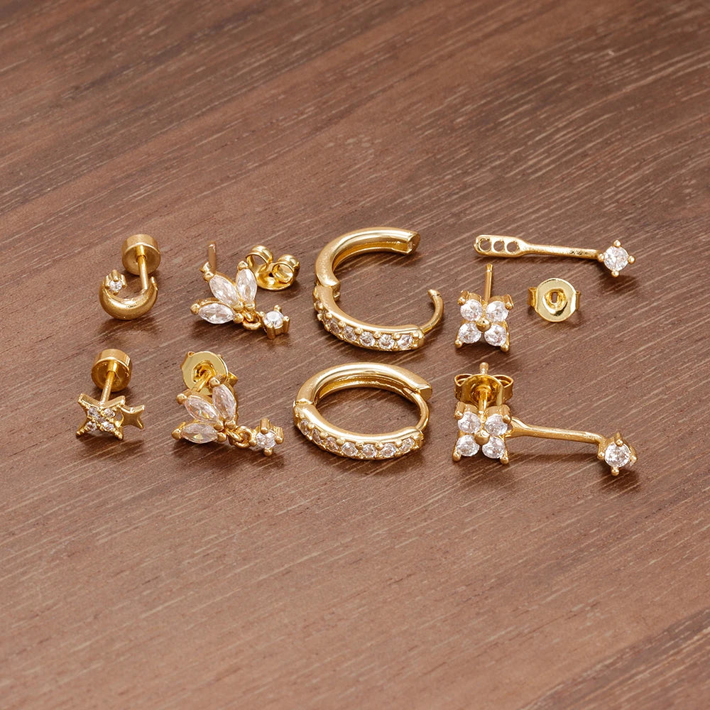 Four small hoop earrings set featuring star, moon, and flower designs in stainless steel by DoubleMfashion.