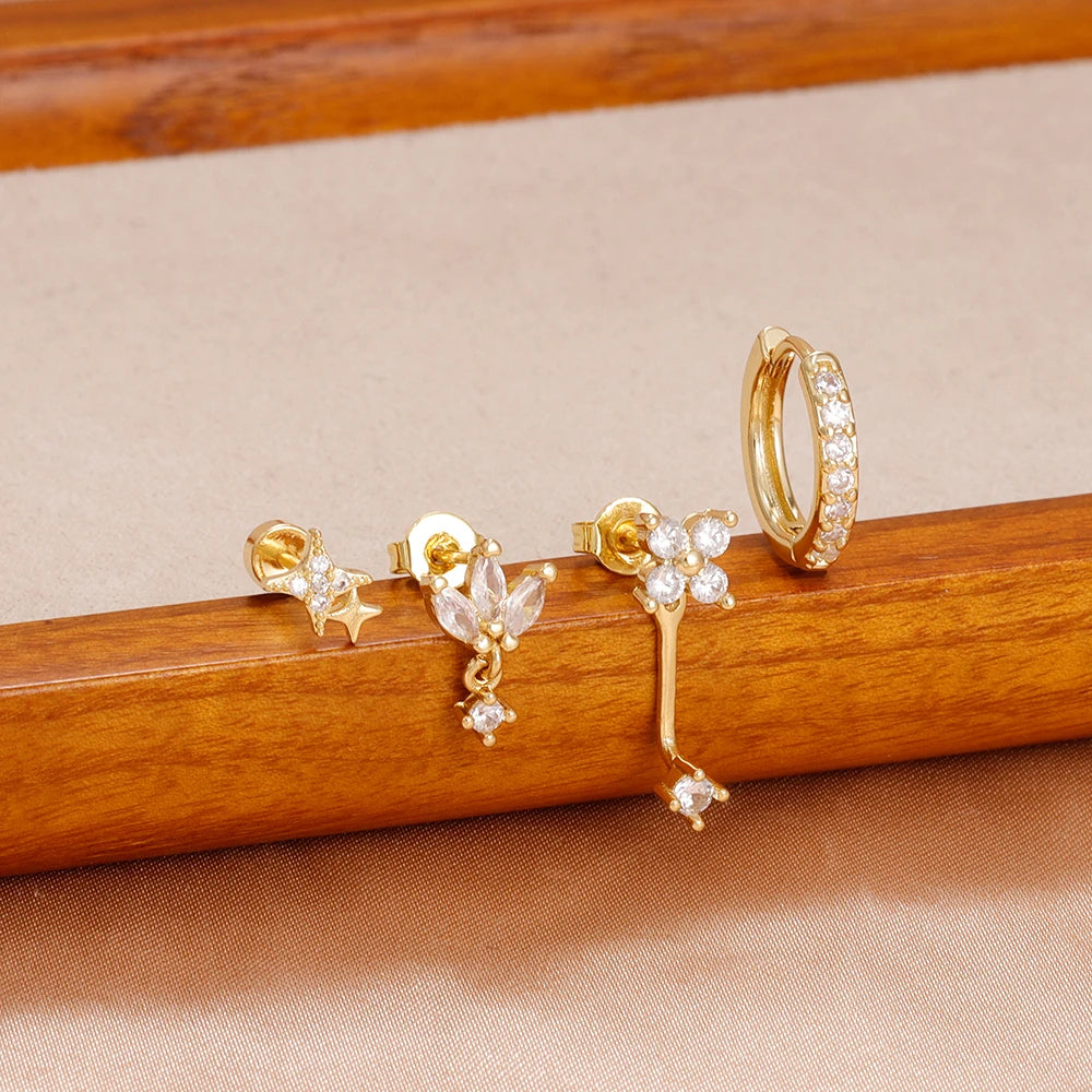 Four small hoop earrings set featuring star, moon, and flower designs in stainless steel by DoubleMfashion.