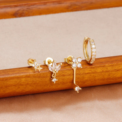 Four small hoop earrings set featuring star, moon, and flower designs in stainless steel by DoubleMfashion.