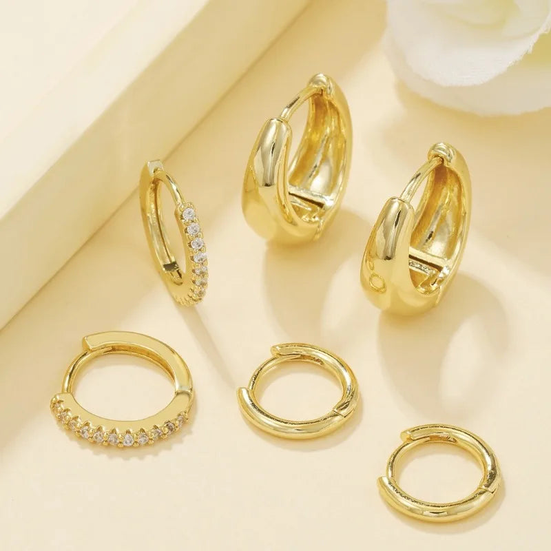 Three pairs of gold-plated stainless steel hoop earrings with crystal zirconia for women, showcasing a trendy punk style.