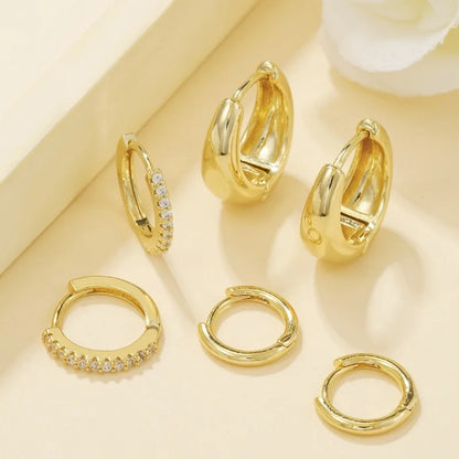 Three pairs of gold-plated stainless steel hoop earrings with crystal zirconia for women, showcasing a trendy punk style.