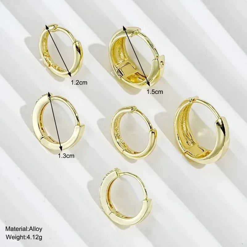 Three pairs of gold-plated hoop earrings with crystal zirconia by DoubleMfashion, showcasing a trendy, simple design.